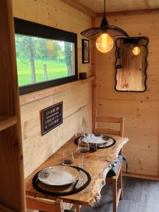 a dining room with a table with wine glasses on it at le cocon d'amour " Roulotte avec jaccuzi privé " in La Chapelle-du-Fest