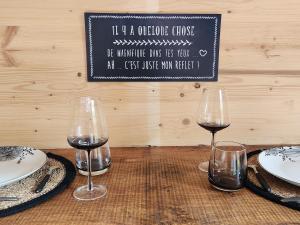 le cocon d'amour " Roulotte avec bain nordique privée" في La Chapelle-du-Fest: طاولة مع كأسين من النبيذ وصحون عليها +6 صور