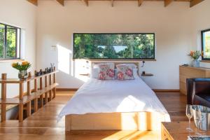 a bedroom with a bed and a large window at Granite Forest Chalet in Cape Town