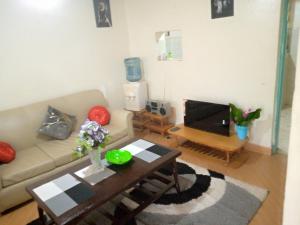 Pelia Rose Guesthouse في كيزيمو: غرفة معيشة مع أريكة وطاولة