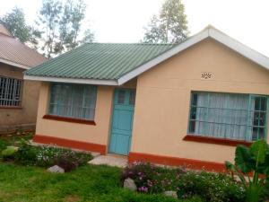 a house with a green roof and blue doors at Pelia Rose Guesthouse in Kisumu