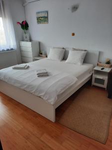 a large white bed in a bedroom with a rug at Pensiunea Corbeanca - cazare si evenimente in Corbeanca