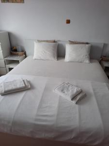 a large white bed with two towels on it at Pensiunea Corbeanca - cazare si evenimente in Corbeanca