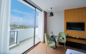 een kamer met een balkon met een tafel en stoelen bij Dragon Sea Hotel in Sầm Sơn