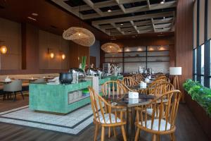 a restaurant with wooden chairs and tables and a counter at Avissa Suites in Jakarta