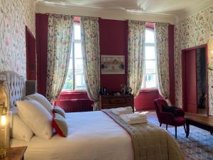 Schlafzimmer mit einem Bett mit roten Wänden und Fenstern in der Unterkunft Les Ordalies in Castelnaudary