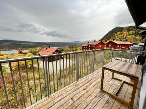 una terraza de madera con un banco en el balcón en Salmons väg Funäsdalen, en Funäsdalen