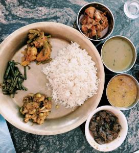 un plato de comida con arroz y otros alimentos en Hotel Garden of Dreams, en Sauraha
