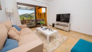 un soggiorno con divano, TV e tavolo di Coto Real Naxos 202 a Manilva