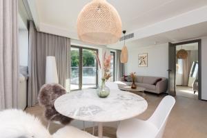 uma sala de estar com uma mesa e cadeiras brancas em Hilltop Apartments - Kiikri Residence City Centre em Talin
