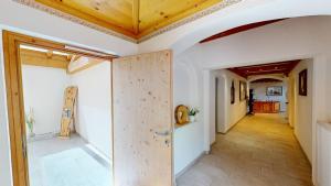 korytarz z drewnianymi drzwiami w pokoju w obiekcie Pitztal Living Apartments w mieście Jerzens