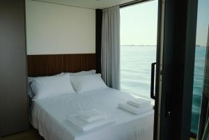 a bedroom with a bed with a view of the ocean at AQVA The Exclusive Water Loft in Venice in Venice