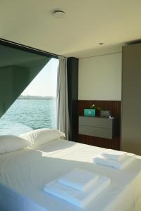 a bedroom with a bed with a view of the water at AQVA The Exclusive Water Loft in Venice in Venice