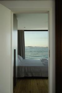a bedroom with a view of the ocean through a door at AQVA The Exclusive Water Loft in Venice in Venice