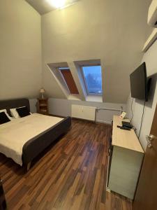 a bedroom with a bed and a flat screen tv at Palank Apartman in Mosonmagyaróvár