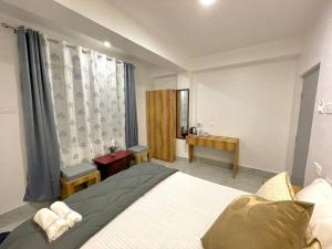 Un dormitorio con una cama grande y una ventana. en Ga-Ki-Khim Homestay, en Gangtok 6 fotos más
