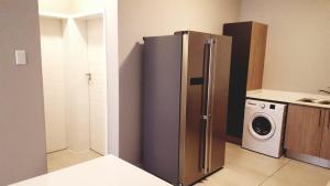 a kitchen with a refrigerator and a washing machine at Midrand Serene Escape in Midrand