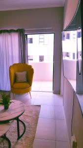 a living room with a yellow chair and a table at Midrand Serene Escape in Midrand