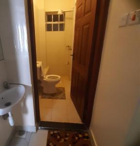 a bathroom with a toilet and a sink and a door at Elegant Furnished 2 bedroom Apartment in Nairobi Ngara in Nairobi