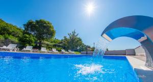 a pool with a water fountain in a resort at Villa Ellie in Ljubuški