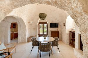 a kitchen and dining room with a table and chairs at Trullo Due Ulivi in Monopoli