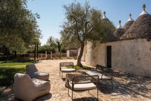 a patio with couches and chairs and a table at Trullo Due Ulivi in Monopoli