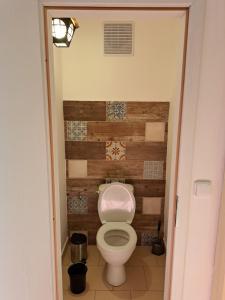 a bathroom with a toilet with a wooden wall at Novomanželský apartmán - 100DOLA in Lanškroun