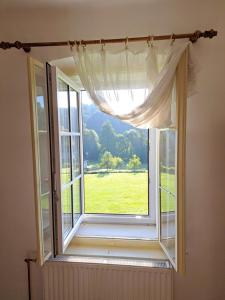 an open window with a view of a green field at Novomanželský apartmán - 100DOLA in Lanškroun