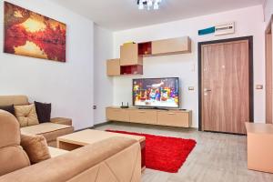 a living room with a couch and a television at Deluxe by Alz in Mamaia Sat/Năvodari