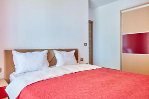 a bedroom with a large bed with a red blanket at Deluxe by Alz in Mamaia Sat/Năvodari