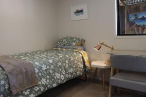 a bedroom with a bed and a desk with a chair at Hidden Gem for business traveller's in Tauranga