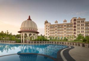 a view of a building with a pool in front of it at Uday Palace Navsari, a member of Radisson Individuals in Navsāri