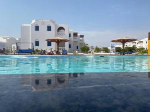 a swimming pool in front of a building at Beach safari nubian resort in Marsa Alam City