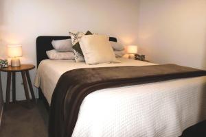 a bedroom with a bed with two lamps on it at Hidden Gem for business traveller's in Tauranga