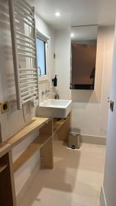 een badkamer met een wastafel en een spiegel bij Haut MaraisJolie duplex 33m2… in Parijs