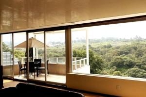 a balcony with a table and chairs and a large window at Views from the Heart of theForest ,Wi-Fi, TV, Terrace in Mexico City