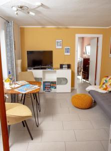 ein Wohnzimmer mit einem Tisch und einem TV in der Unterkunft Haus Haeger in Dahme