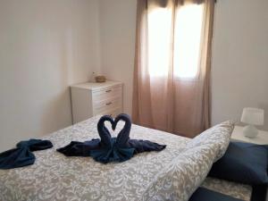 een slaapkamer met twee handdoeken in hartvorm op een bed bij Mirador de Sotavento apartment 8241 in Costa Calma