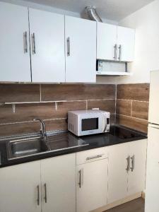 een keuken met een wastafel en een magnetron bij Mirador de Sotavento apartment 8241 in Costa Calma