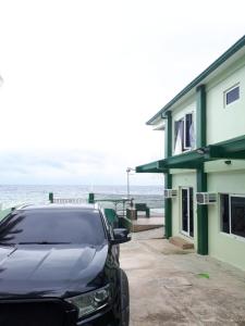 CatmonにあるKums Vacation Houseの海辺の建物の外に駐車した車