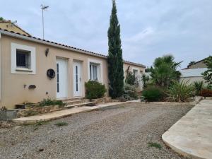 a house with a gravel driveway in front of it at Dépendance T3 in Aumes