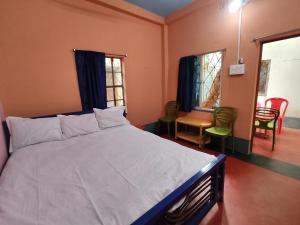 1 dormitorio con 1 cama, mesa y sillas en Atithi Nibas Home stay, 