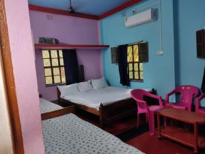 Habitación con 2 camas, mesa y sillas en Atithi Nibas Home stay, 