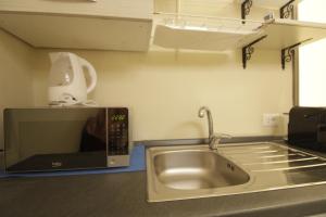 a kitchen with a sink and a microwave at Elegante Suite con giardino in centro storico in Pavia