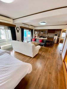 a living room with a white bed and a dining room at La Foret Fujimi in Hiroshima