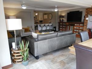 a living room with a large couch and a television at 94 Sea Cottage in Mossel Bay