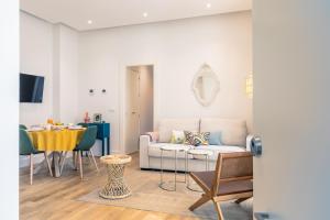 een woonkamer met een bank en een tafel bij Magno Apartments Casa del Correo Mayor II in Sevilla