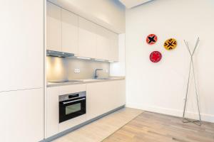kuchnia z białymi szafkami i lodówką w obiekcie Magno Apartments Casa del Correo Mayor II w Sewilli