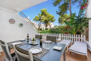 uma sala de jantar com mesa, cadeiras e árvores em Edisol 29 -Villa Pilar 2- em Port d'Addaia