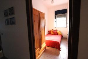 Habitación con cama roja y ventana en Casa vite, en Forza dʼAgro